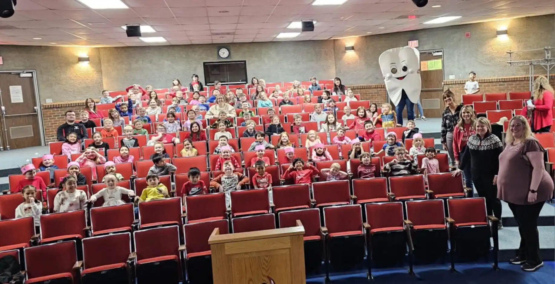 Auditorium of school kids learning about dental best practices